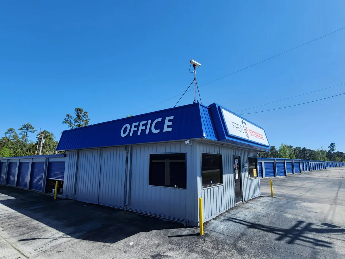 Blue and gray self-storage office beside rows of blue storage doors.